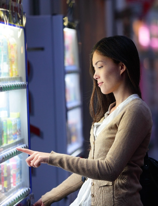 Une jeune femme utilisant une distributrice automatique