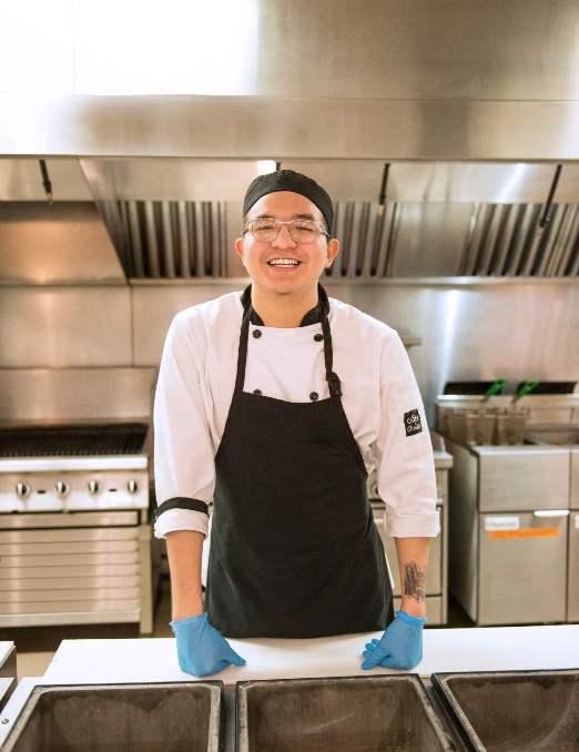 chef smiling and standing in front of counter